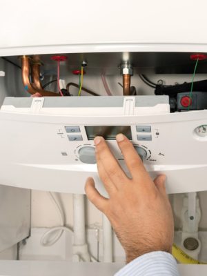 Boiler Installation and Replacement - image of man putting cover on combi boiler